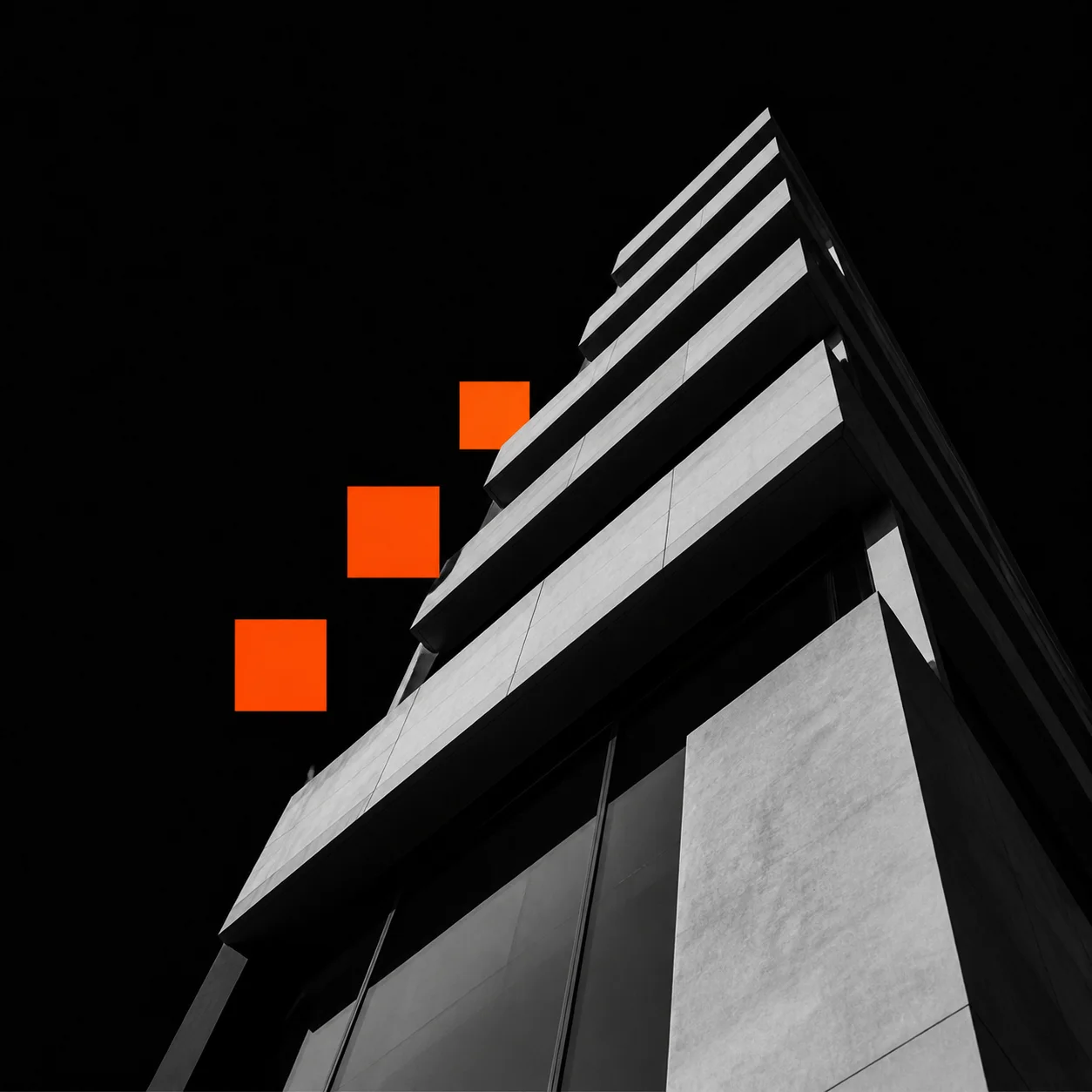Modern tower rising against a black sky with orange modules