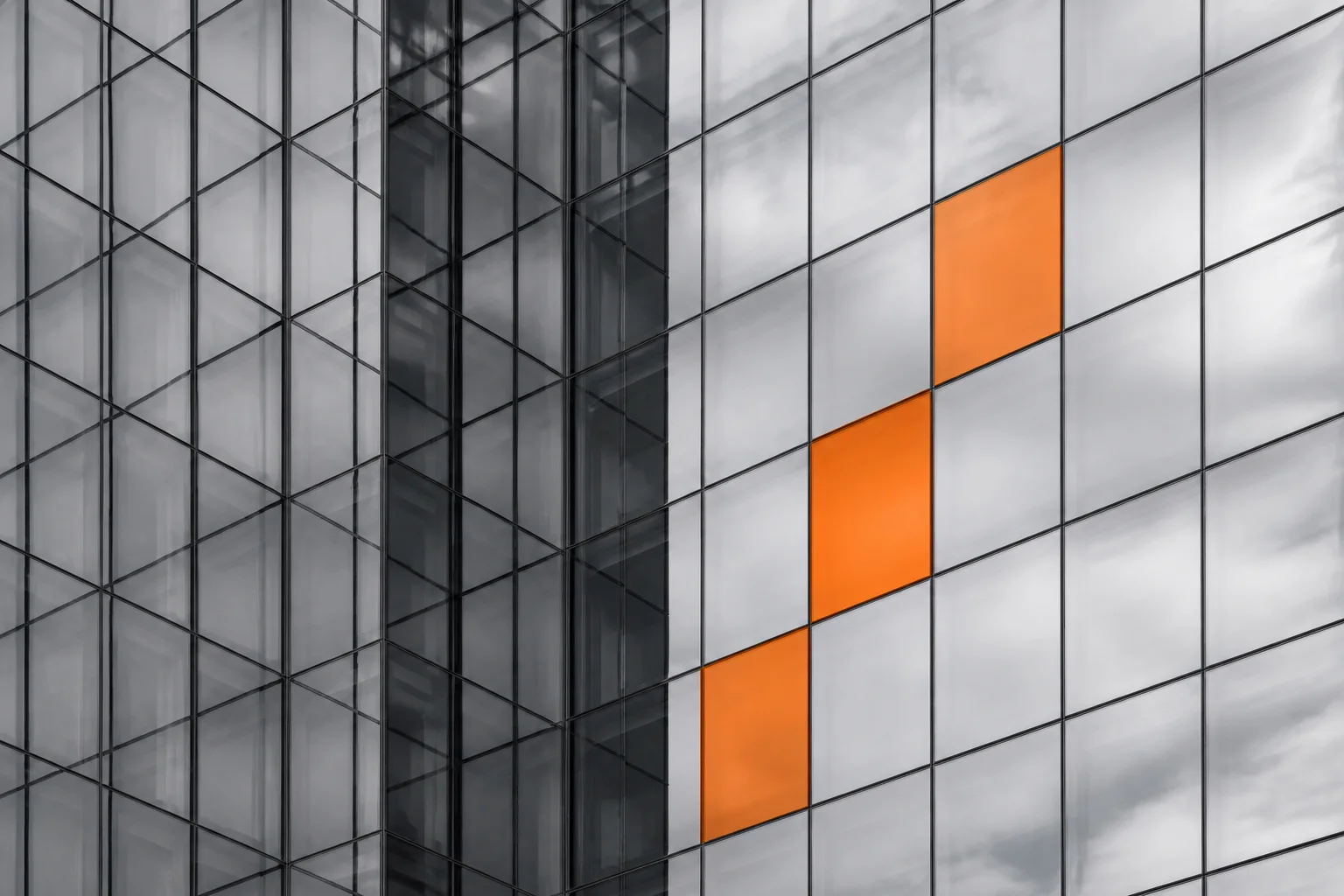Glass facade with orange modules in a precise grid
