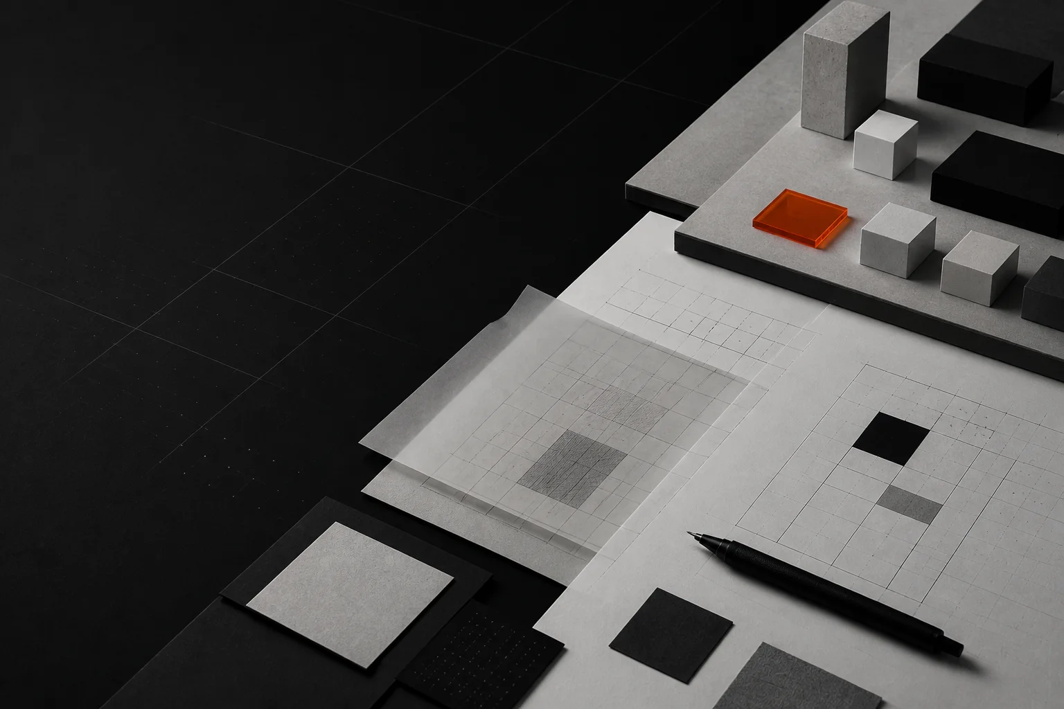 Architectural wireframes, modular blocks, and a black technical pen arranged on a gridded workbench